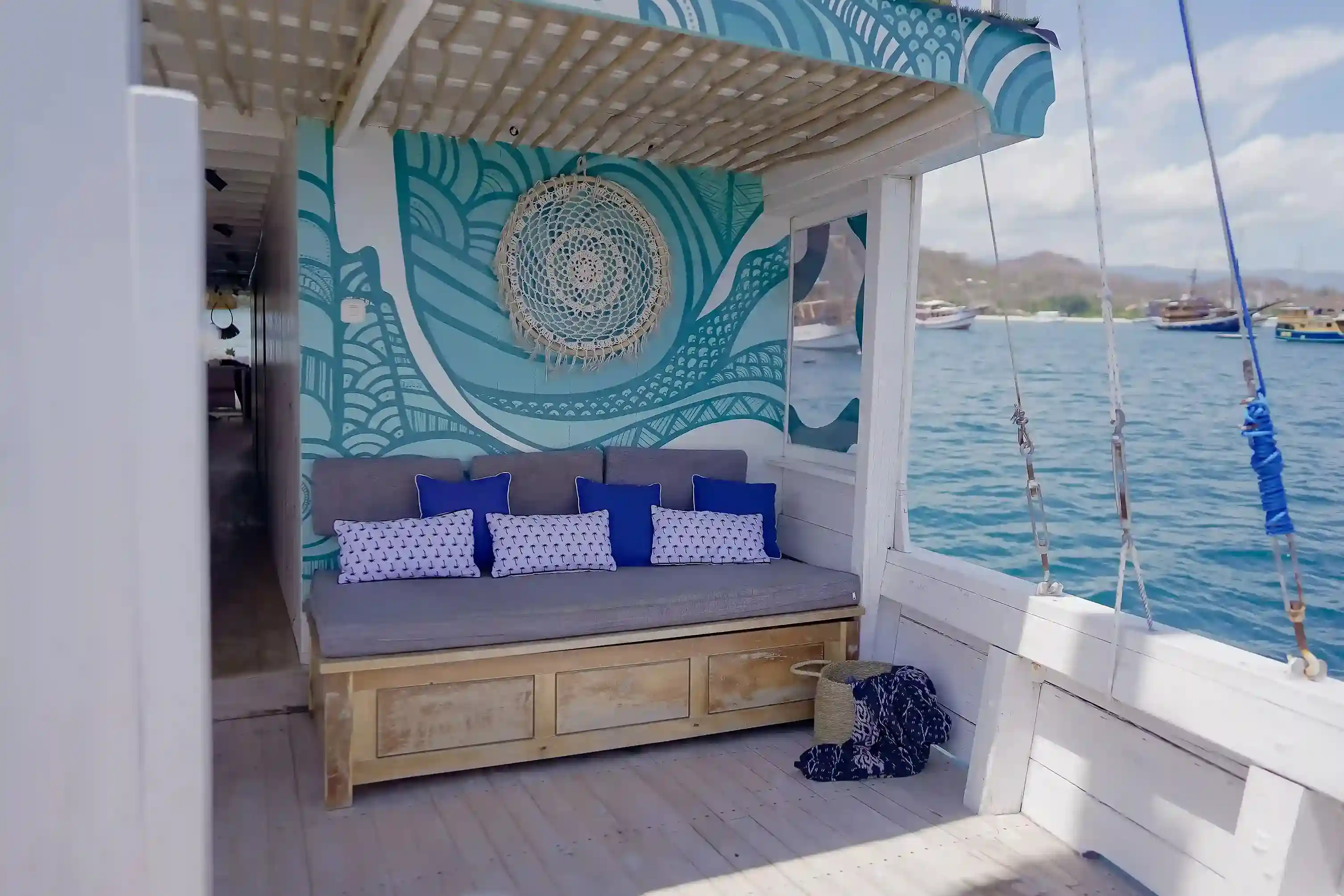 The shaded deck lounge of a phinisi at anchor